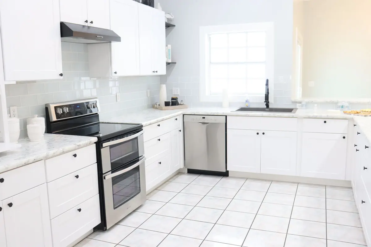 White U-shaped kitchen with stainless steel appliances