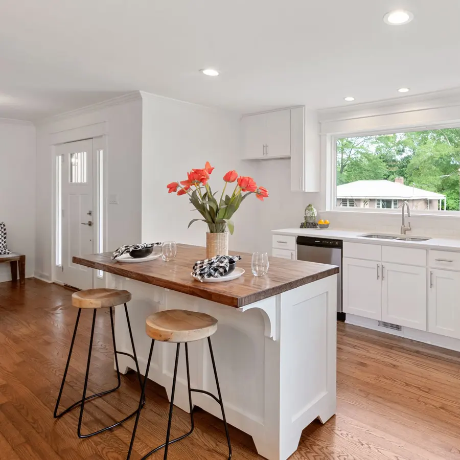 Bright kitchen with a wood-top island and white cabinets