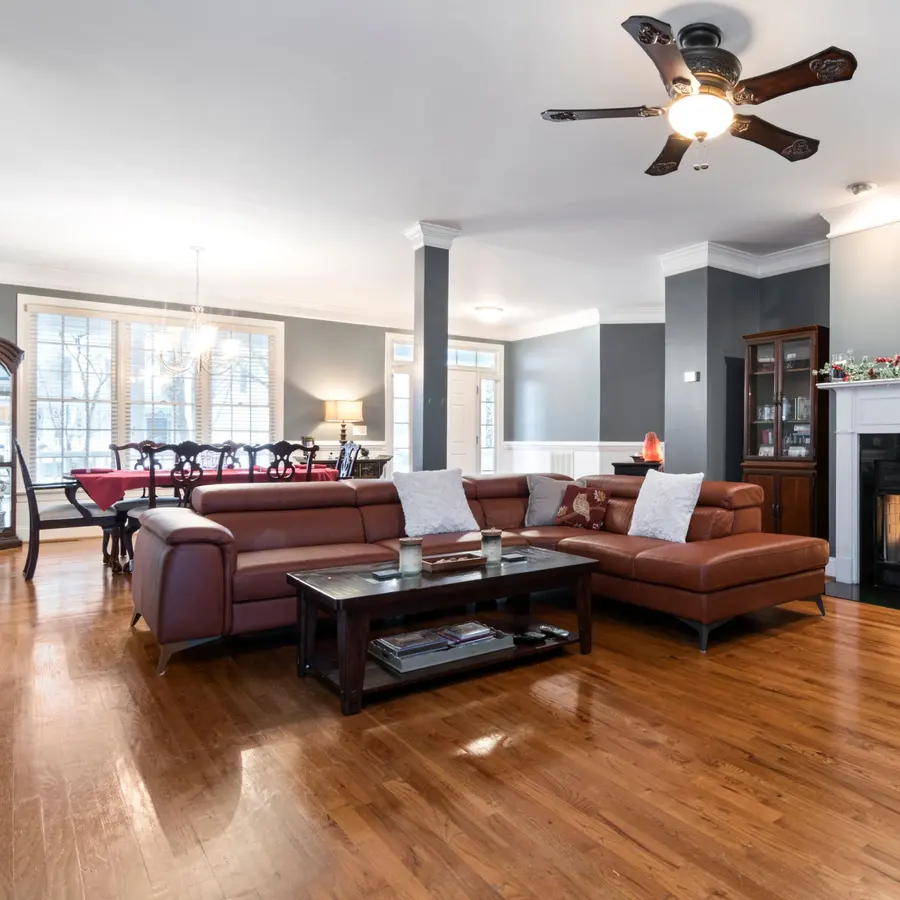 Living room with crown molding, a fireplace and wood floors