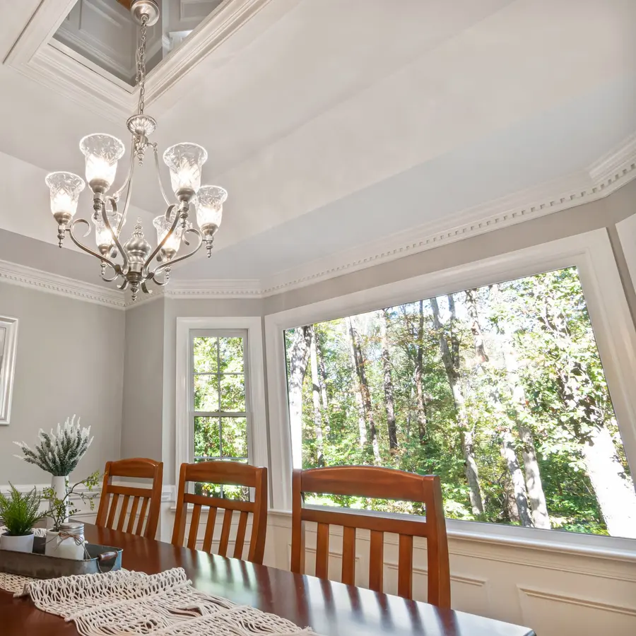 Dining room with a tray ceiling, crown molding and a chandelier