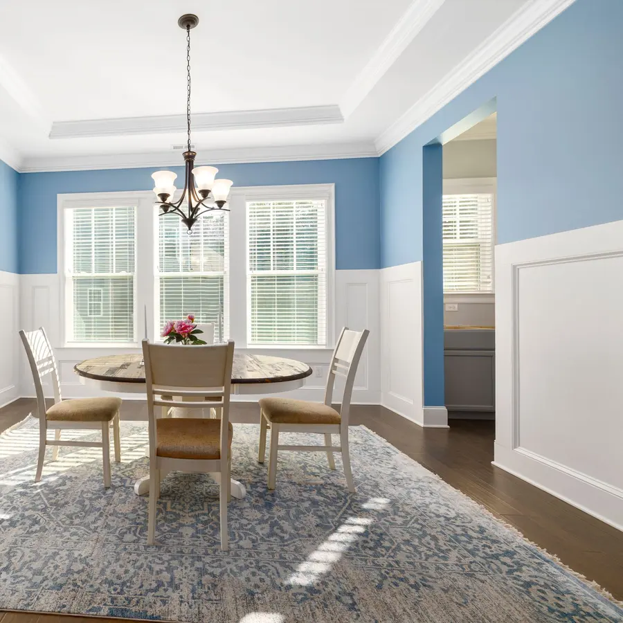 Blue dining room with white wainscoting and a coffered ceiling
